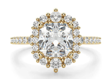 A cushion cut engagement ring with a central moissanite stone and round cut accents along the band.