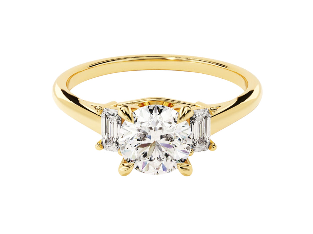 A gold engagement ring with a central moissanite diamond and two emerald cut accents