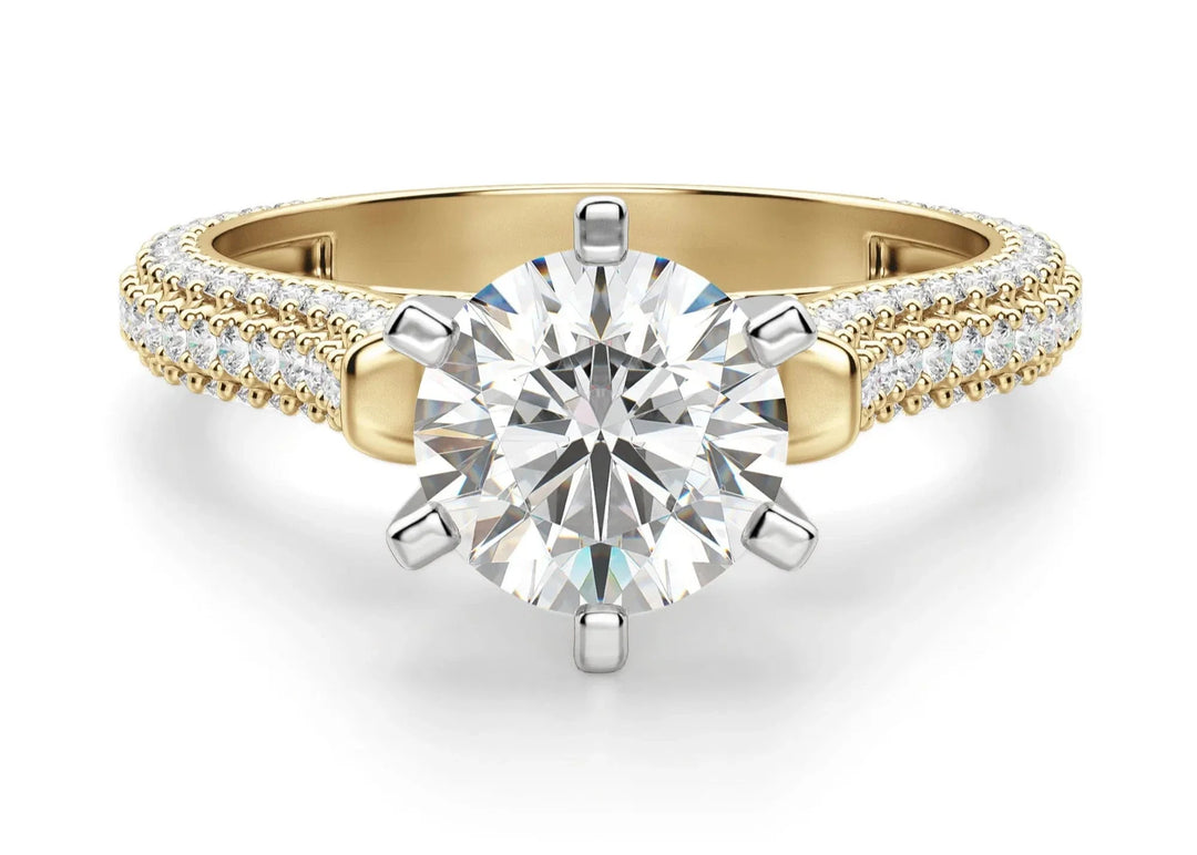 A round-cut moissanite engagement ring with a gold band and pavé set accent stones along the top and arched side.