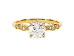 Load image into Gallery viewer, A round cut moissanite engagement ring with wave sidestones, set in a gold band with milgrain detailing.
