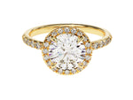 Load image into Gallery viewer, A round cut moissanite ring with a halo design, featuring a larger center stone surrounded by smaller accent stones set in a gold band.