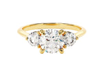 Load image into Gallery viewer, A round cut three stone moissanite engagement ring with a 1.50 ct center stone and two side stones, set in a solid gold band.