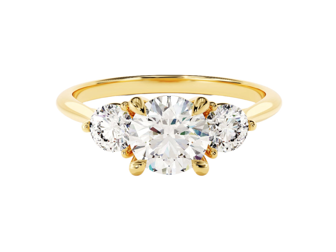A round cut three stone moissanite engagement ring with a 1.50 ct center stone and two side stones, set in a solid gold band.