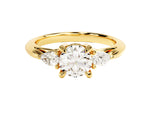 Load image into Gallery viewer, A three stone moissanite engagement ring with pear cut accents, featuring a round-cut center stone and pear-shaped side stones, set in a gold band.