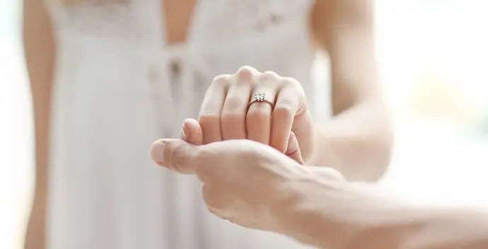 Two hands holding each other and love ring with a soft focus background