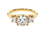 Load image into Gallery viewer, A gold-colored, three-stone round moissanite engagement ring with two smaller round accent stones