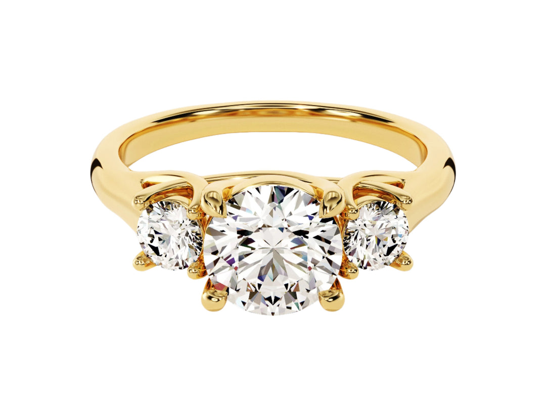 A gold-colored, three-stone round moissanite engagement ring with two smaller round accent stones
