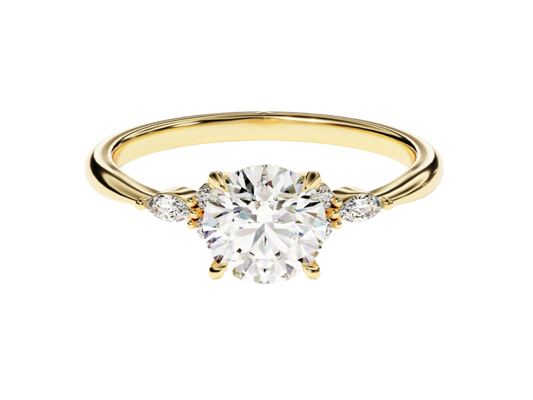 A gold-banded ring with a round cut moissanite center stone and smaller round accent stones on the band.