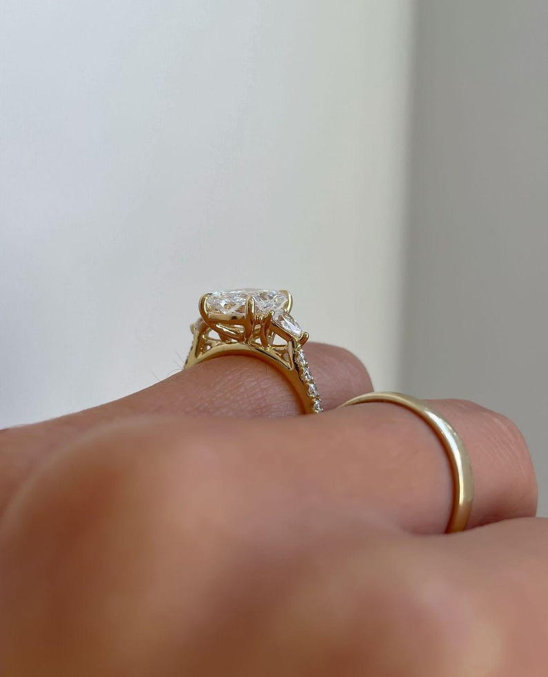 Close-up of radiant 3.0tcw lab grown diamond ring with raised cathedral setting, sparkling pave band, and hidden halo design. This sophisticated engagement ring is perfect for weddings, proposals, or anniversary celebrations. A luxurious and timeless diamond ring for her.