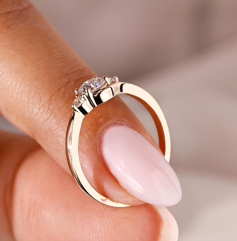 3 stone diamond ring with a round cut diamond in the center for added sparkle.