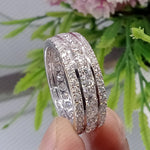 Load image into Gallery viewer, May include: A silver band ring with three rows of round, clear diamonds. The ring is set in a polished metal band.
