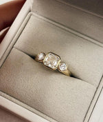Load image into Gallery viewer, Asscher Cut Trilogy Diamond Engagement Ring featuring a 1.5ct IGI Certified Asscher Cut Lab Grown Diamond with round lab grown diamond side stones in solid gold. Three-stone engagement ring with 1.82ct total carat weight.