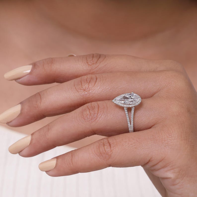 Lab grown pear shaped diamond halo engagement ring with split shank band in sterling silver