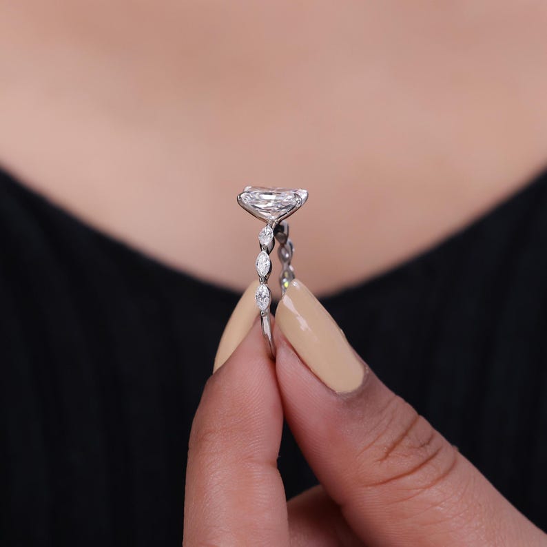 Radiant cut lab grown diamond engagement ring with marquise side stone set in prong and created in 14k gold.
