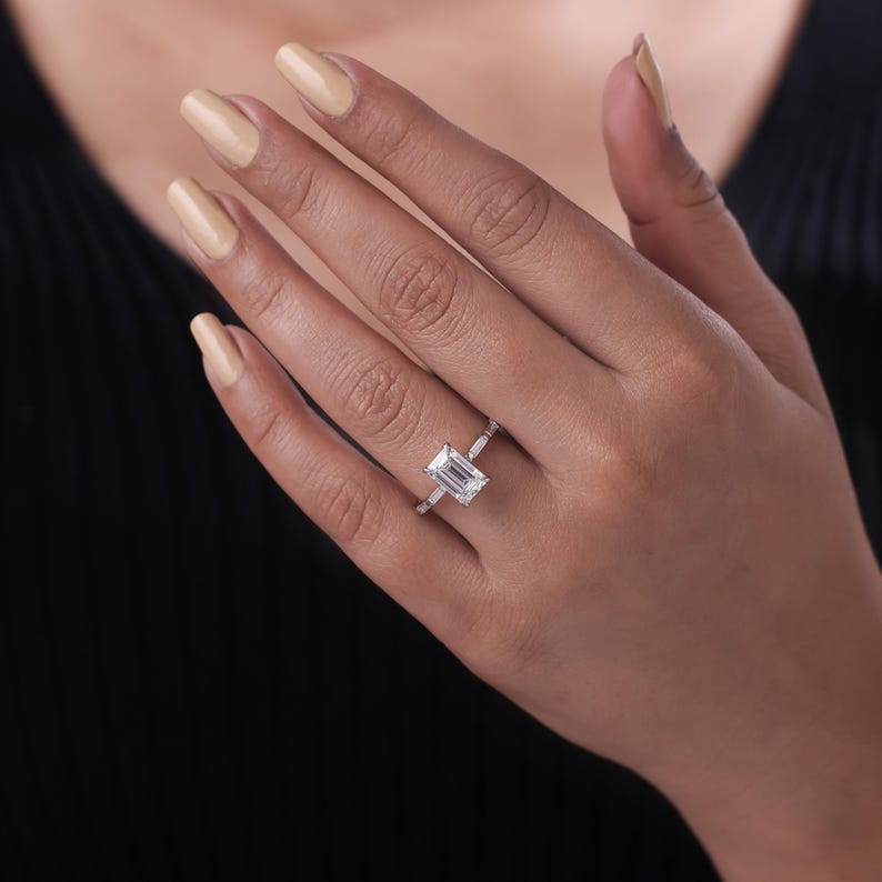 Lab grown emerald cut diamond side stone engagement ring.